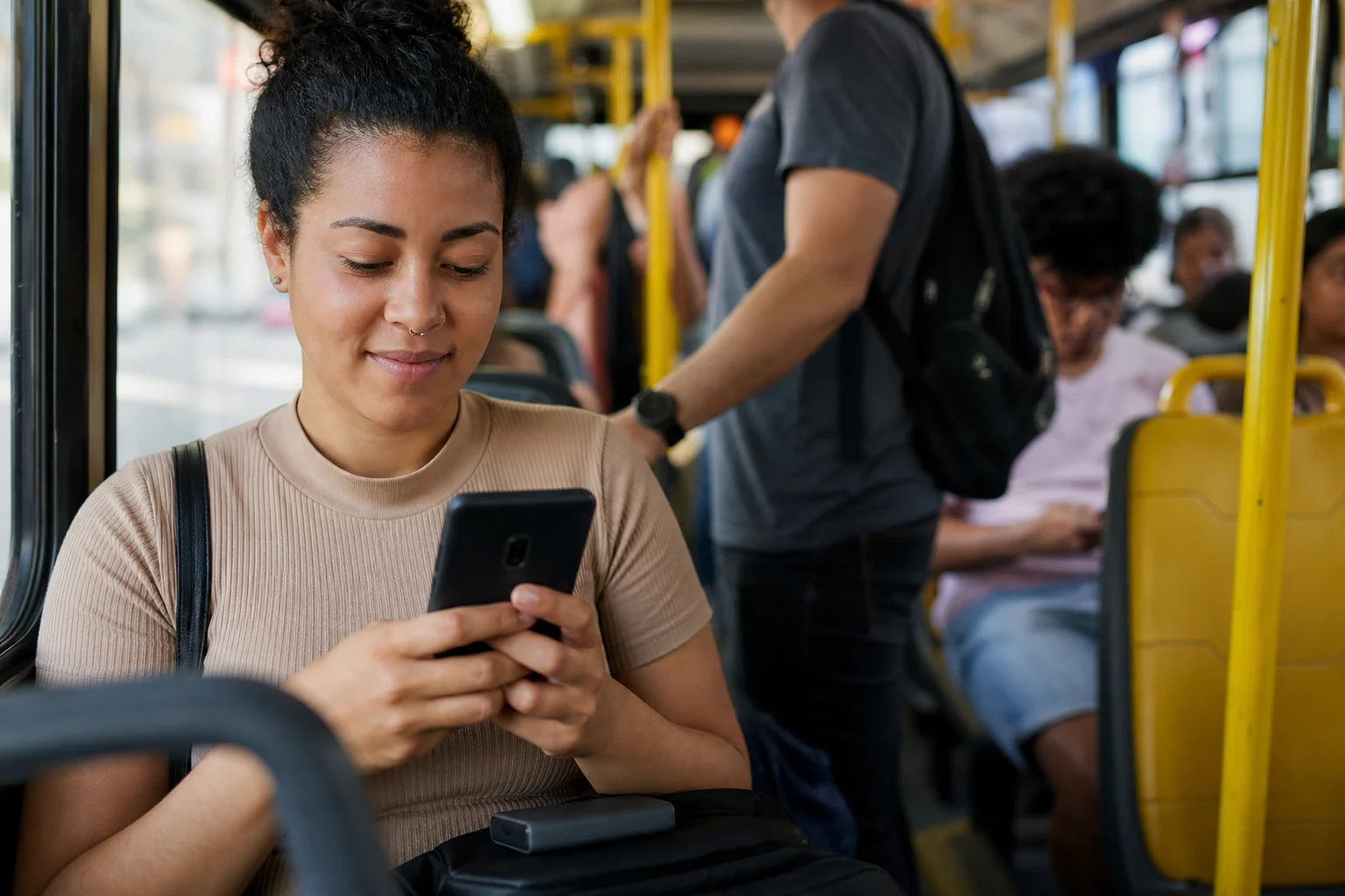 pessoa usando celular durante o dia em transporte público