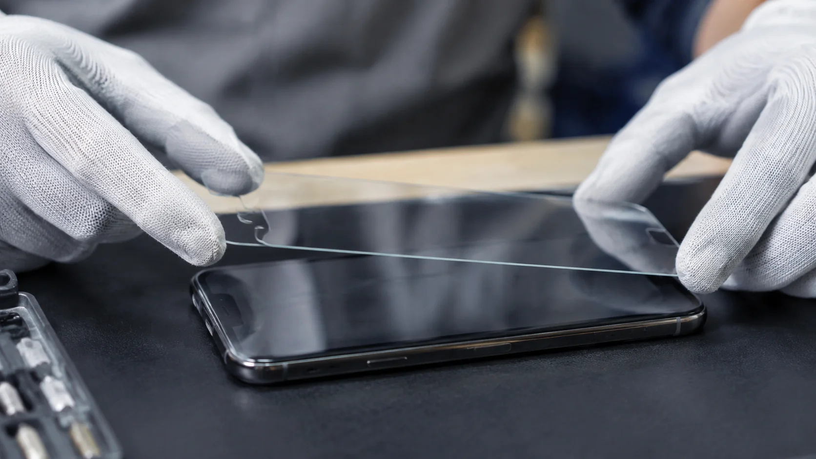 Aplicação cuidadosa de película rígida transparente em smartphone
