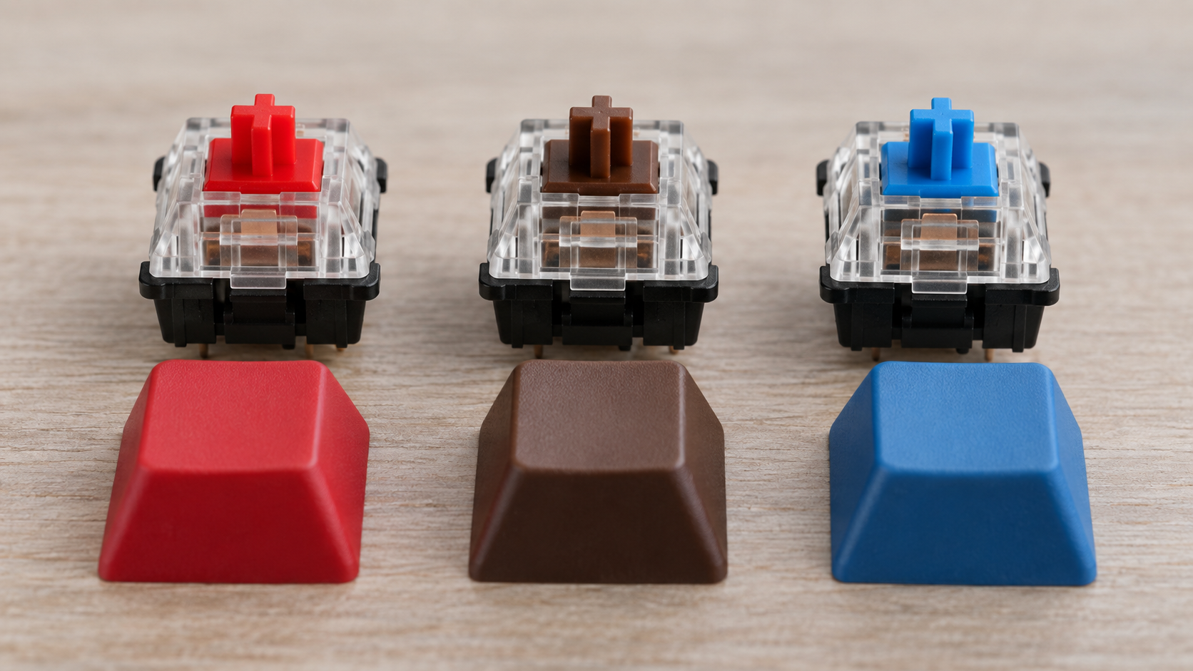 Três switches mecânicos com hastes vermelha, marrom e azul